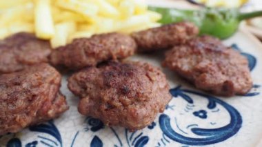 Sıcak bir lokantada altın kızartmaların yanında leziz köftelerin tadını çıkarıyorum..