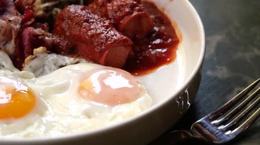 Kızarmış yumurta ve soslu leziz sosisle doyurucu bir kahvaltı yapın..