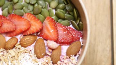 Çilek ve fındıkla kaplı lezzetli bir meyve suyu kasesinin tadını çıkar..