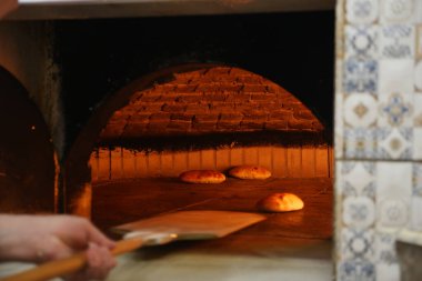 Taze ekmek kırsal bir fırında pişiriliyor, sıcak bir parıltı sergiliyor..