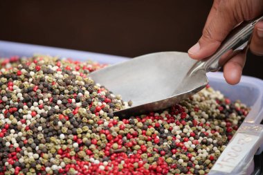 Bir el yerel bir markette canlı bir biber karışımı kepçeler..