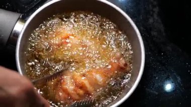 Tavuk parçaları ocakta kızgın yağda kızarırken cızırdar..