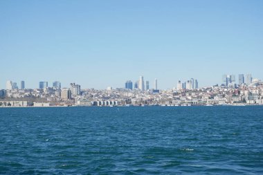 Açık bir günde sudan görünen canlı bir şehir silueti..