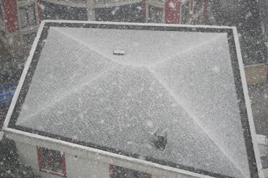 Çatılara şiddetli kar yağarak şehir manzarasını kışa dönüştürüyor..