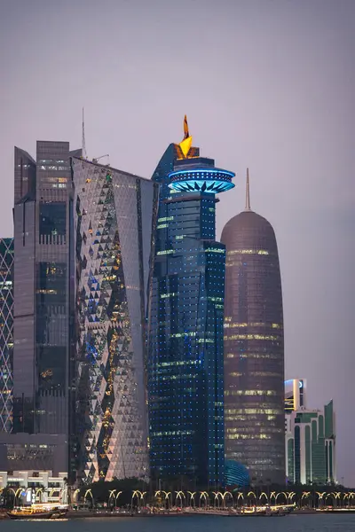 Şehrin üzerine akşam çökerken uzun binalar ışıklarla parıldıyor..