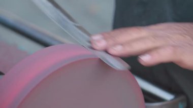 Bir atölyede bıçağı ustalıkla bilemek..