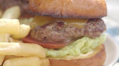 Sıcak bir lokantada kızarmış patatesle servis edilen lezzetli hamburger..