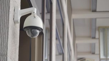 Bir güvenlik kamerası binanın girişini yakalar ve güvenliği sağlar..