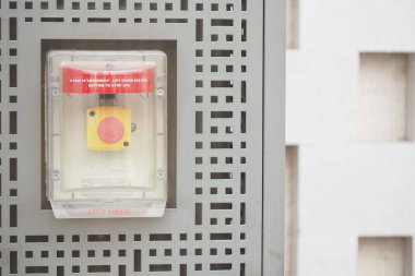 Güvenlik için bir bina duvarına yerleştirilmiş acil durum kaldırma düğmesi.