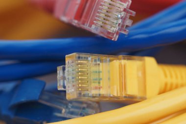 Parlak renkli çeşitli ethernet kabloları bir masanın üzerinde birbirine dolanmış..