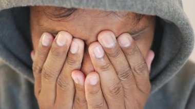 Bir insan yüzünü gizler, kapüşon giyerken duygularını aktarır..