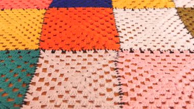 Parlak yama battaniyesi canlı renkler ve dokular sergiler.