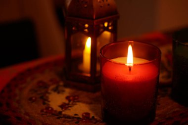 Masadaki güzel tutacakların içinde parlayan mumlarla dolu rahat bir ortam..