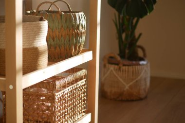 Yakınlarda bir bitkinin bulunduğu bir rafta doğal dokuma sepetleri sergileniyor..