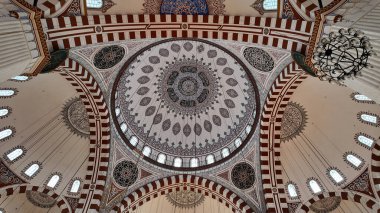 Renkli ve ayrıntılı desenler antik bir caminin tavanını süslüyor..