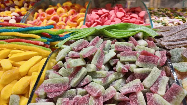 Marketteki temiz konteynırlarda düzenlenmiş canlı şekerleme seçimi.