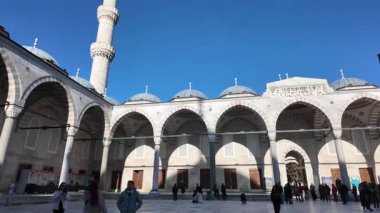 Ziyaretçiler tarihi bir caminin güzel kemerlerine ve kubbelerine hayran..