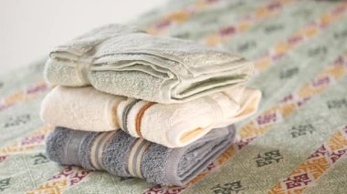 Yumuşak havlular düzenlenir ve dekoratif bir yatak örtüsüne dizilir..