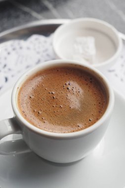 Türk kahvesi yanında küp şekerle birlikte beyaz bir fincanda servis edilir..