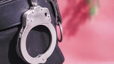 Polis kemerine takılmış kelepçelere yakından bak..