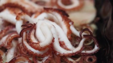 Şefler ustalıkla bir sahil lokantasında taze ahtapot yemeği hazırlarken izleyin..