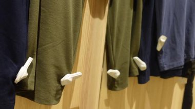 Güvenlik etiketleri mağazadaki hırsızlığı önlerken giysiler askıda asılı duruyor..