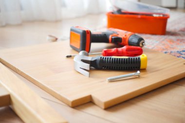 Çeşitli araç ve gereçler ahşap bir yüzeye yerleştirilir ve montaj için hazırlanır..