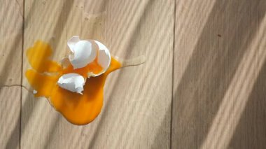 Yumurtalar ahşap bir yüzeyde kırılarak, parlak sarı bir yumurta sarısı oluşturur..