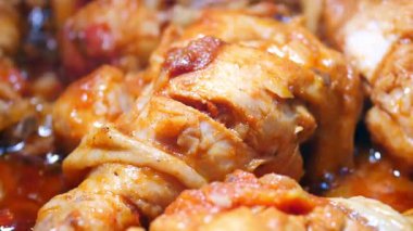 Sulu tavuk parçaları sosta kaynıyor, mutfağı aromalarla dolduruyor..