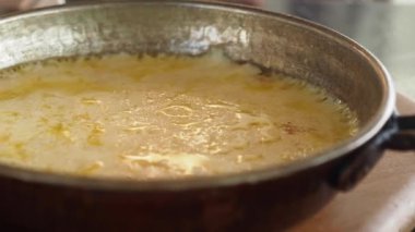 Erimiş peynir tavada kaynıyor, lezzetli bir lezzet yaratıyor..