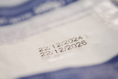 Gıda ambalajındaki son kullanma tarihlerinin yakın plan görüntüsü açıkça gösteriliyor.