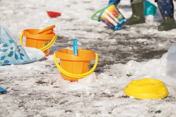 Eğlenceli olsun diye karlı araziye dağılmış renkli çocuk kovaları..