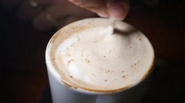 Üstünde köpük olan lezzetli bir fincan kahveyi yudumlarken.