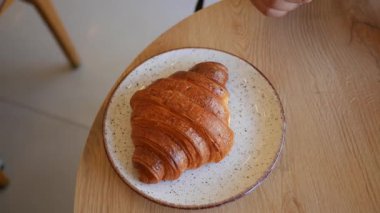 Evde dinlenirken tereyağlı kruvasanın tadını çıkarmak..