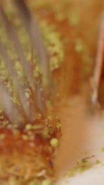 Cevizli altın bir pastayı kesen bir çatalın yakın çekimi..