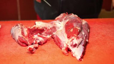 Yetenekli kasap, kalabalık pazar ortamında et kesme teknikleri gösteriyor..