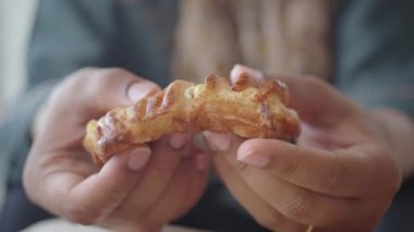 Bir insan sıcak bir kafede dinlenirken lezzetli bir pastanın tadını çıkarır..