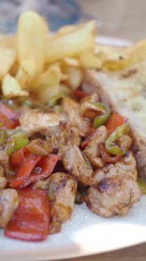 Sıcak bir ortamda tavuk, biber ve patates kızartmasının tadını çıkarmak..