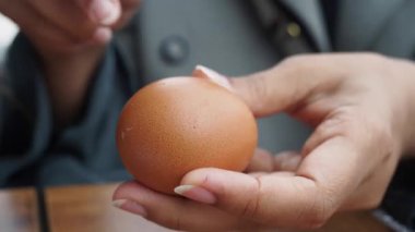 Bir insan pişirme tezgahında kaynamış bir yumurtayı dikkatlice keser..