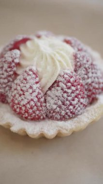 Taze çilekli turta, krema ve şekerle süslenmiş, zarif bir şekilde duruyor..