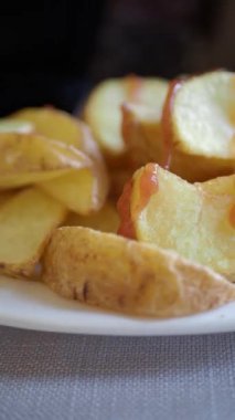 Lezzetli kızarmış patatesler, beyaz bir tabakta servis ediliyor, yemeye hazır..