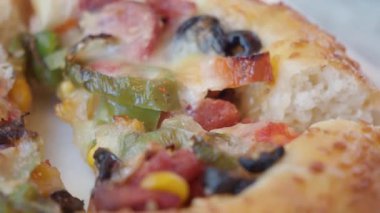 Canlı malzemelerle dolu taze pişmiş pizzanın tadını çıkarın..