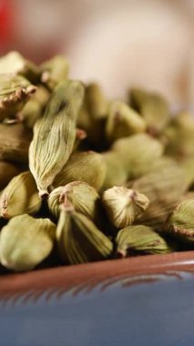 Kırsal bir kasede dizilmiş yeşil kakule kapsüllerinin yakın görüntüsü.