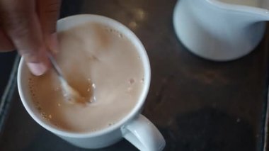 Chai çayının ustalıkla karıştırılıp sıcak bir içecek oluşturulmasını izleyin..