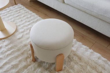 Yumuşak, yuvarlak bir sedir, modern bir dinlenme odasındaki lüks bir kilimin üzerinde duruyor..