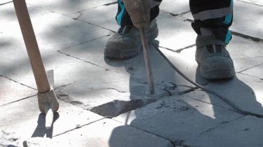 İnşaat ekibi dışarıda ağır aletlerle kaldırımı tamir ediyor..