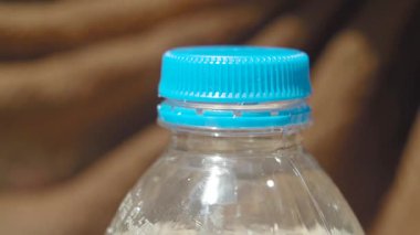 Plastik bir su şişesinin kapağını aç. .