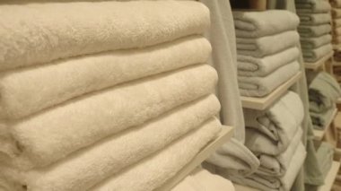 Sakinleştirici atmosfer yumuşak renklerde beyaz havluları düzgünce istifler..