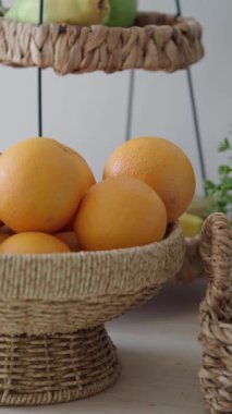 Portakallar, yakınlarda yeşillik bulunan dokuma sepetine yerleştirilmiş..