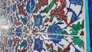 Karmaşık fayanslar canlı çiçek desenleri ve renkler sergiliyor.